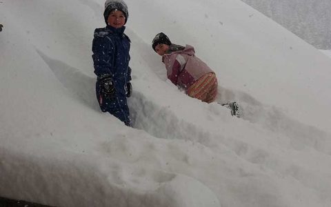 Zwei Kinder spielen im tiefen Schnee am Kinderbauernhof Steffenegg, Familienurlaub Österreich